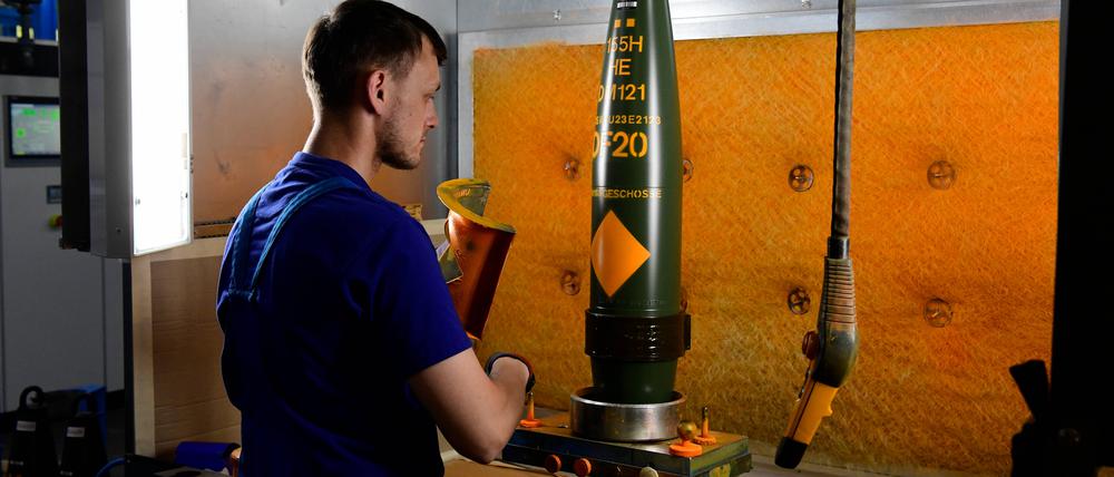 Ein Mitarbeiter von Rheinmetall am Standort Unterlüss bei der Lackierung und Endkontrolle von Geschossen.