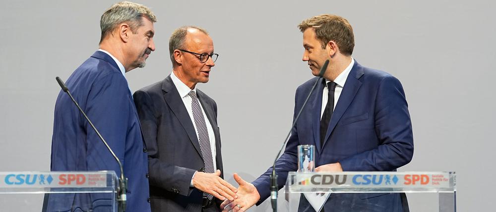 09.04.2025, Berlin: Friedrich Merz (M), Unions-Kanzlerkandidat und CDU-Bundesvorsitzender, und Lars Klingbeil (r), SPD-Fraktions- und Bundesvorsitzender, geben sich nach einer Pressekonferenz der Parteivorsitzenden von Union und SPD zur Vorstellung des Koalitionsvertrages im Paul-Löbe-Haus die Hand. Links steht Markus Söder, Ministerpräsident von Bayern und CSU-Vorsitzender. (zu dpa: «Experte: Schwarz-Rot plant zweistellige Milliardenentlastung») Foto: Michael Kappeler/dpa +++ dpa-Bildfunk +++