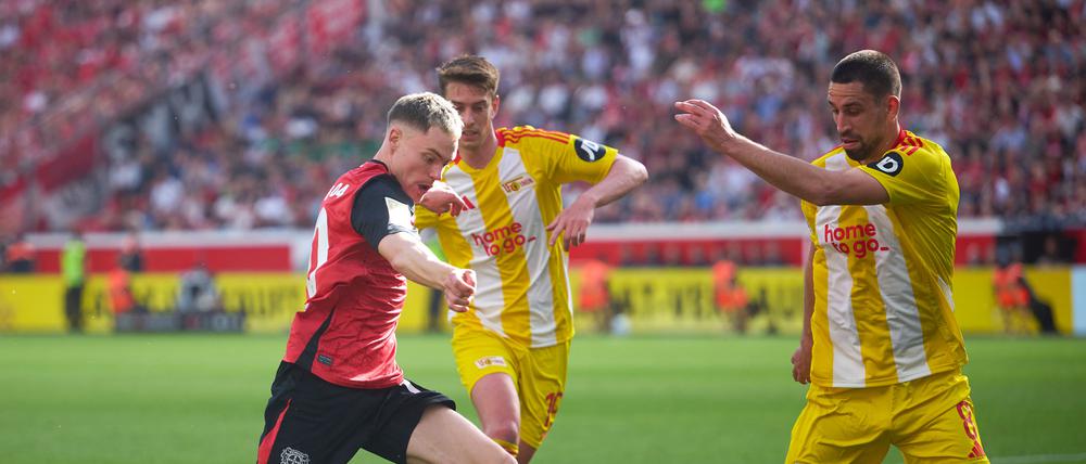 Florian Wirtz (links) kehrte nach wochenlanger Verletzungspause zurück, hatte es gegen Unions Rani Khedira (rechts) und Janik Haberer aber schwer.