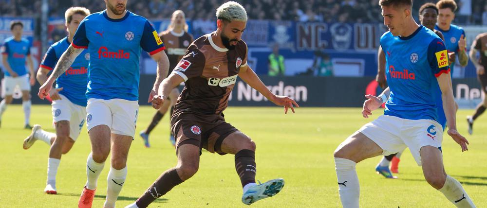 Kiels Marco Komenda (l-r), St. Paulis Elias Saad und Kiels Marko Ivezic kämpfen um den Ball.