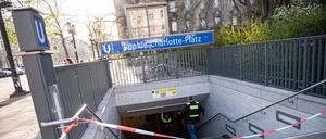 Berliner Polizisten stehen nach einer Gewalttat bei dem U-Bahn Eingang Sophie-Charlotte-Platz. 