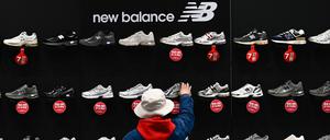 Eine Frau kauft New Balance-Sneakers, die in einem Einkaufszentrum in Peking zum Verkauf angeboten werden.