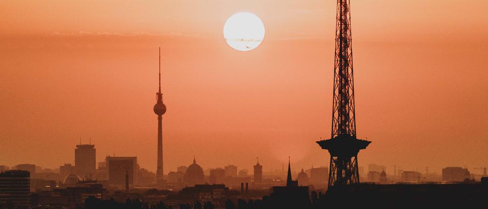 Der Sonnenaufgang zeichnet sich ab hinter der Stadtsilhouette mit dem Fernsehturm und dem Funkturm in Berlin (Archivbild)