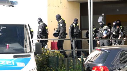 Polizisten stehen vor dem Eingangsbereich eines Hauses in der Sonnenallee.