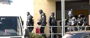 Polizisten stehen vor dem Eingangsbereich eines Hauses in der Sonnenallee.