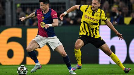 Barcelonas Robert Lewandowski (l) und Dortmunds Waldemar Anton kämpfen um den Ball.