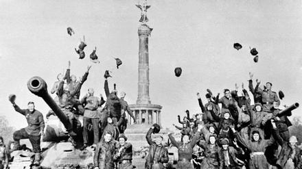 Sowjetische Soldaten feiern das Kriegsende auf ihren Panzern vor der Siegessäule in Berlin und werfen ihre Mützen in die Luft. (Archivbild)