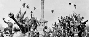 Sowjetische Soldaten feiern das Kriegsende auf ihren Panzern vor der Siegessäule in Berlin und werfen ihre Mützen in die Luft. (Archivbild)