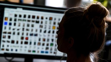 Ein Kriminaloberkommissarin sitzt in einem Büro vor einem Auswertungscomputer und ermittelt gegen Kindesmissbrauch im Internet.