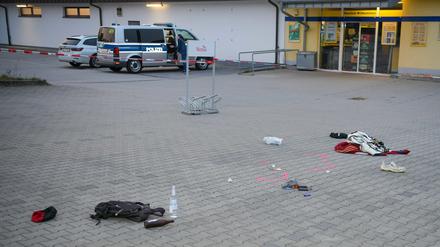 Gegenstände liegen verstreut auf einem Parkplatz: Vor einem Supermarkt sind zwei Menschen bei einem Messerangriff schwer verletzt worden.