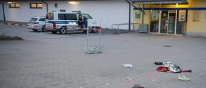 Gegenstände liegen verstreut auf einem Parkplatz: Vor einem Supermarkt sind zwei Menschen bei einem Messerangriff schwer verletzt worden.