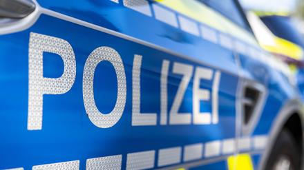 An der Tür von einem Streifenwagen steht der Schriftzug „Polizei“. 