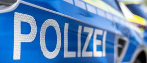 An der Tür von einem Streifenwagen steht der Schriftzug „Polizei“. 