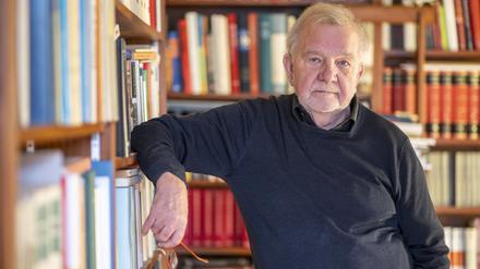 Der Philosoph Rüdiger Safranski steht in seinem Haus vor einem Bücherregal.