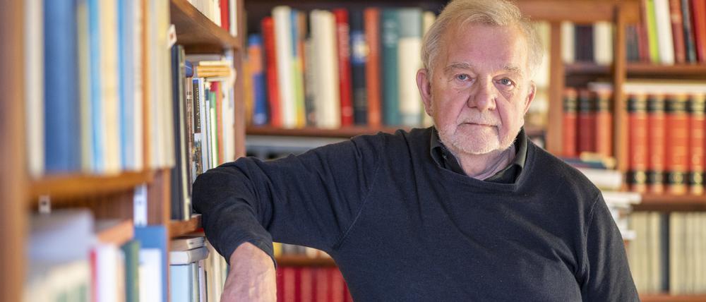Der Philosoph Rüdiger Safranski steht in seinem Haus vor einem Bücherregal.