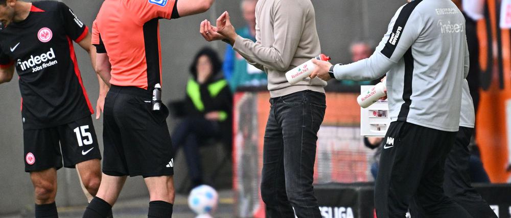 Aufreibender Tag am Spielfeldrand: Frankfurts Trainer Dino Toppmöller (r) bekommt von Schiedsrichter Florian Badstübner die Gelbe Karte gezeigt.