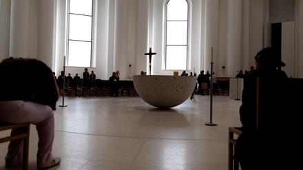 Menschen sitzen in der Sankt Hedwigskathedrale. Heute ist Papst Franziskus gestorben.