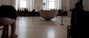 Menschen sitzen in der Sankt Hedwigskathedrale. Heute ist Papst Franziskus gestorben.