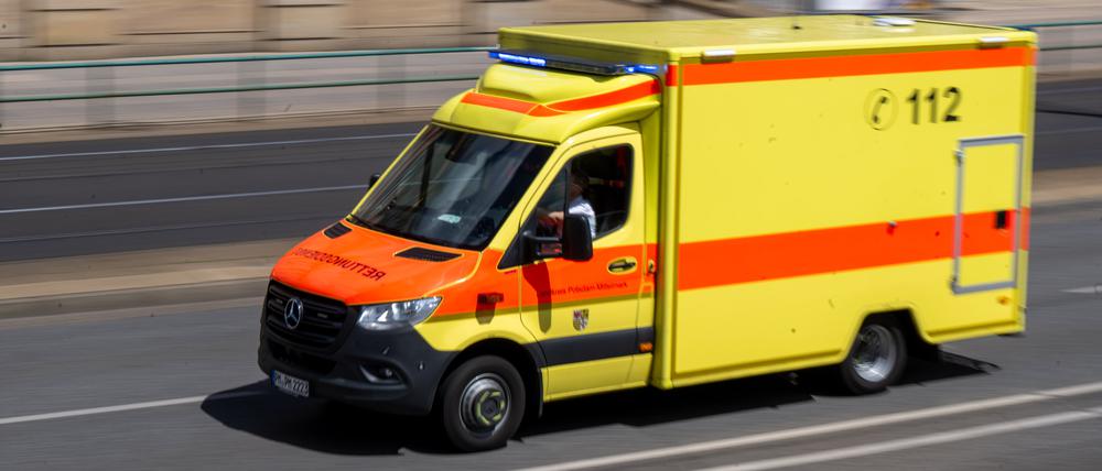 Ein Rettungswagen mit Blaulicht fährt über eine Straße. (Symbolbild)