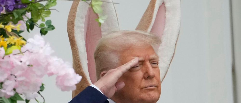 Donald Trump steht vor einem großen Osterhasen - und es sieht so aus, als hätte er sich die Ohren geliehen.