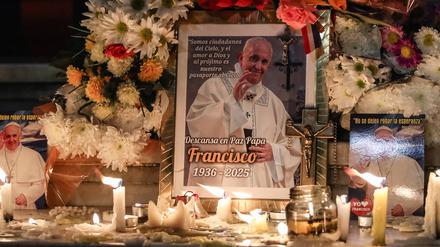 Blumen und Kerzen sind in Buenos Aires in Argentinien neben einem Foto des verstorbenen Papstes drapiert.
