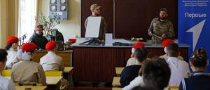 Russische Soldaten demonstrieren Schulkindern ein Starlink-Terminal in der Region Donezk am 11. April 2025.