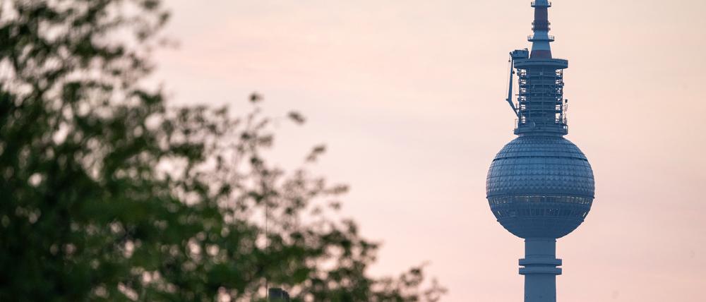 Das Morgenrot scheint hinter dem Berliner Fernsehturm.