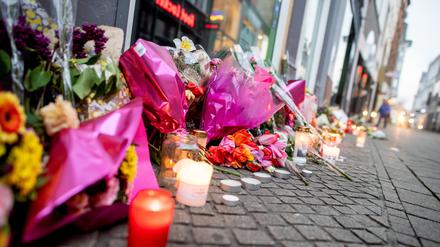 Blumen und Kerzen stehen in der Innenstadt an einer Hauswand in der Achternstraße, in der am Ostersonntag ein Mensch von Schüssen aus einer Polizeiwaffe tödlich verletzt wurde.