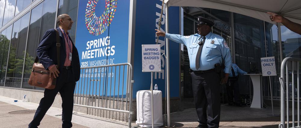 Ein Polizeibeamter (r) des Internationalen Währungsfonds (IWF) weist den Delegierten während der Frühjahrstagung von Weltbank und IWF am Sitz des Internationalen Währungsfonds (IWF) den Weg zum Gebäude.