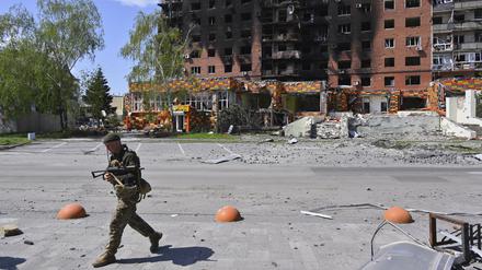 23.04.2025, Ukraine, Pokrowsk: Ein ukrainischer Soldat geht an beschädigten Gebäuden im Zentrum von Pokrowsk vorbei.