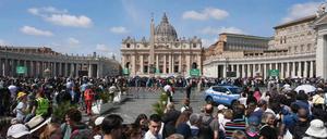 Pilger und Besucher stehen auf dem Petersplatz Schlange, um den Petersdom zu betreten. 