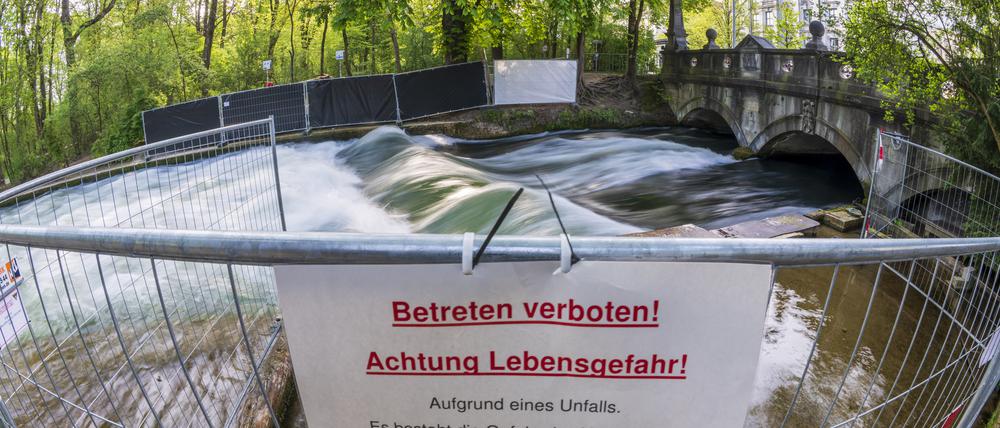 Ein Schild mit der Aufschrift Betreten verboten! Achtung Lebensgefahr! Hängt an einer Absperrung vor der künstlichen Welle am Eisbach.