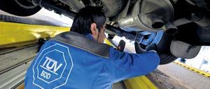 Ein Mitarbeiter des TÜV Süd kontrolliert am 09.06.2009 auf einem Prüfstand des TÜV in München (Bayern) den Unterboden und das Fahrwerk eines Autos.