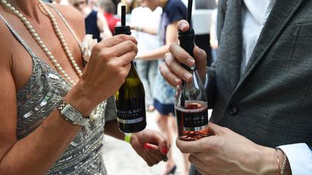 Small Talk mit Prosecco: Gäste unterhalten sich am Rande einer Modenschau in Berlin. (Archivbild)