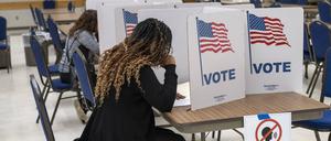 Eine Frau sitzt im November 2024 im US-Bundesstaat Virginia in einer Wahlkabine.