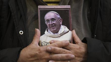 Ein Gläubiger hält ein Porträt des verstorbenen Papstes Franziskus in der Basílica de San José de Flores, wo er als Jugendlicher verehrt wurde, nach der Bekanntgabe seines Todes durch den Vatikan. 