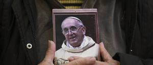 Ein Gläubiger hält ein Porträt des verstorbenen Papstes Franziskus in der Basílica de San José de Flores, wo er als Jugendlicher verehrt wurde, nach der Bekanntgabe seines Todes durch den Vatikan. 
