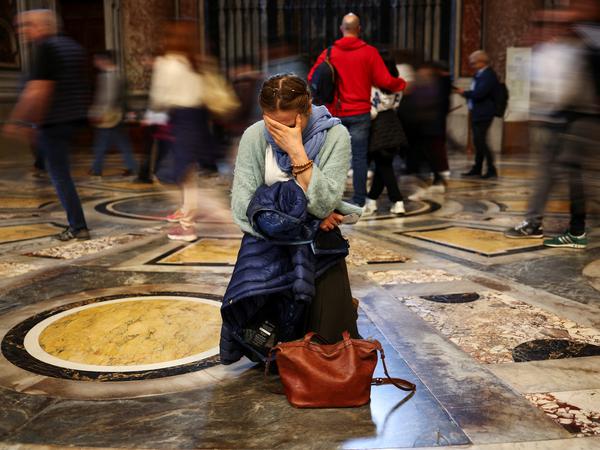 A woman reacts as Pope Francis lies in state in St. Peter's Basilica, at the Vatican, April 25, 2025. REUTERS/Carlos Barria