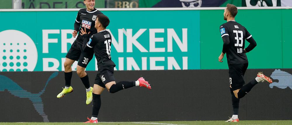 Die Ulmer Spieler feiern Matchwinner Maurice Krattenmacher (l) nach seinem Treffer.