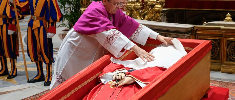 Papst Franziskus wird ein Leinentuch über das Gesicht gelegt.