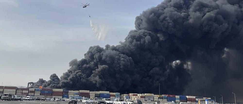 Ein Hubschrauber wirft Wasser auf das Feuer, nachdem eine massive Explosion einen Hafen in der Nähe der südlichen Hafenstadt Bandar Abbas erschüttert hat. 