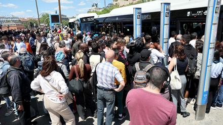 Menschen warten in Massen an einer Station in Madrid. 