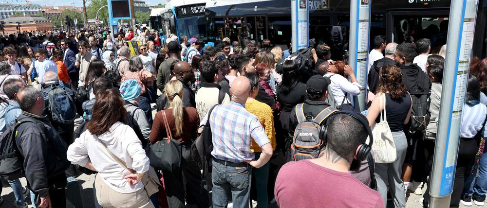 Menschen warten in Massen an einer Station in Madrid. 