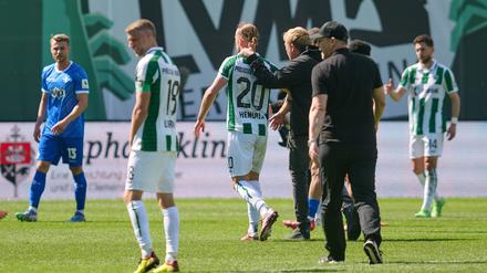 Münsters Trainer Sascha Hildmann geht nach dem Spiel über den Rasen.