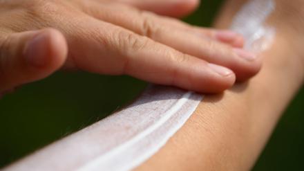 Eine Frau schmiert sich ihren Unterarm mit Sonnencreme ein.