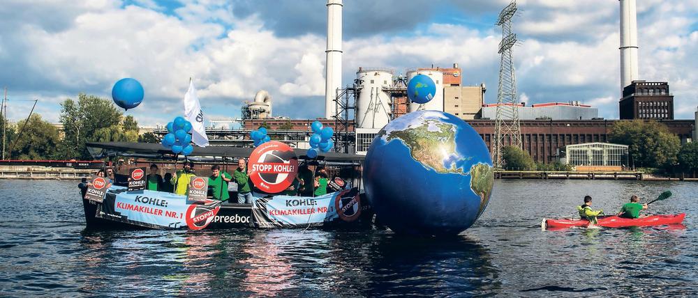 Ein Boot mit Transparenten zieht am 26.09.2015 in Berlin eine nachgebildete Weltkugel vor dem Kraftwerk Klingenberg (Symbolbild).