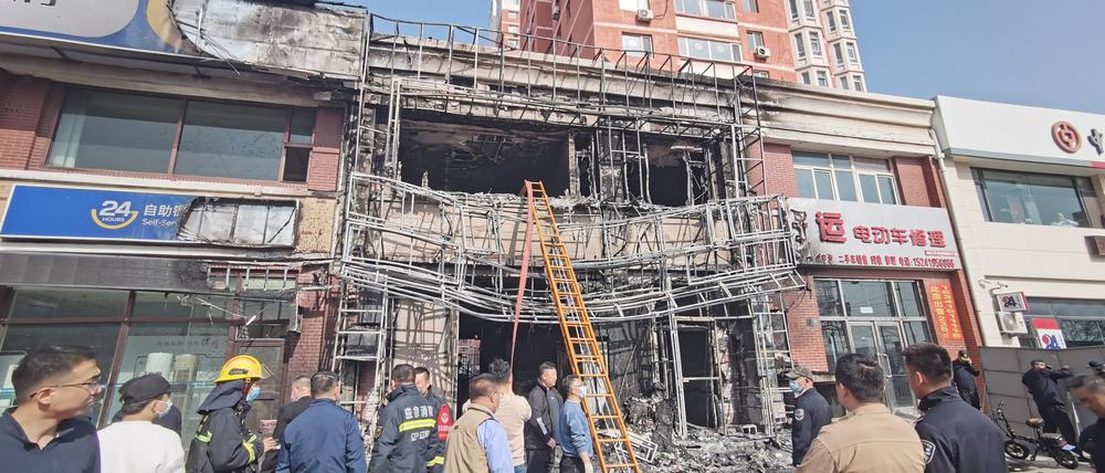 Menschen stehen vor einem Restaurant in Liaoyang in der nordostchinesischen Provinz Liaoning in dem es gebrannt hatte.