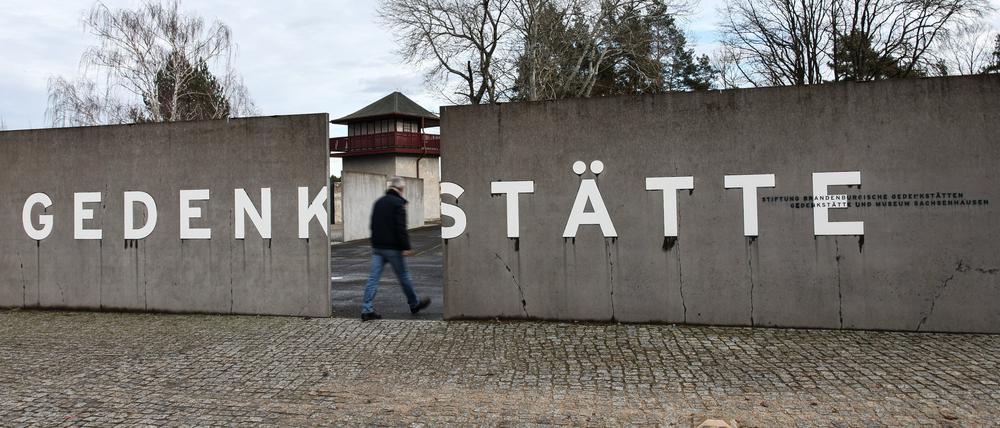 Ein Mann geht zwischen zwei Mauerstücken mit der Aufschrift „Gedenkstätte“ in der Gedenkstätte Sachsenhausen (Symbolbild).