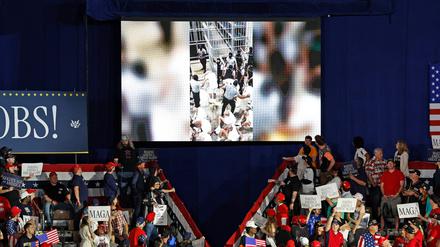 Ein Video aus dem CECOT-Gefängnis in El Salvador ist auf einem Bildschirm zu sehen, während US-Präsident Donald Trump am 29. April 2025 im Macomb County Community College Sports Expo Center in Warren, Michigan, seine Rede zum 100. Tag im Amt hält.