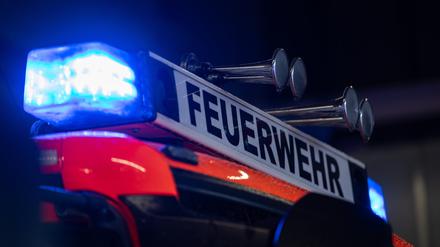Ein Einsatzfahrzeug der Feuerwehr steht mit Blaulicht da.